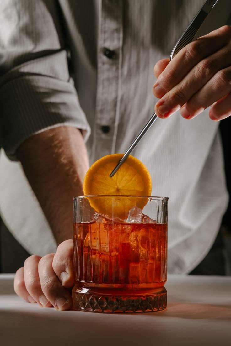 Un cocktail preparato al banco con una fetta d'arancia